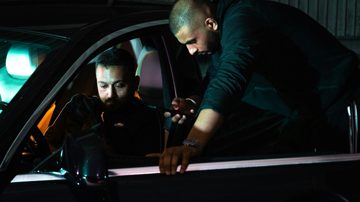 Mobile locksmith helping beside a parked vehicle