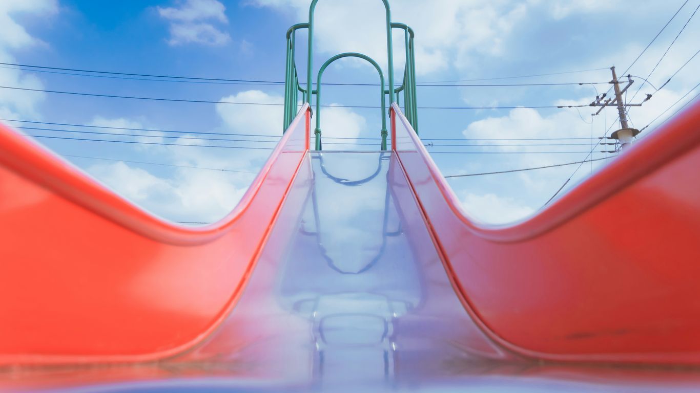 People enjoying colorful water slides at an outdoor park