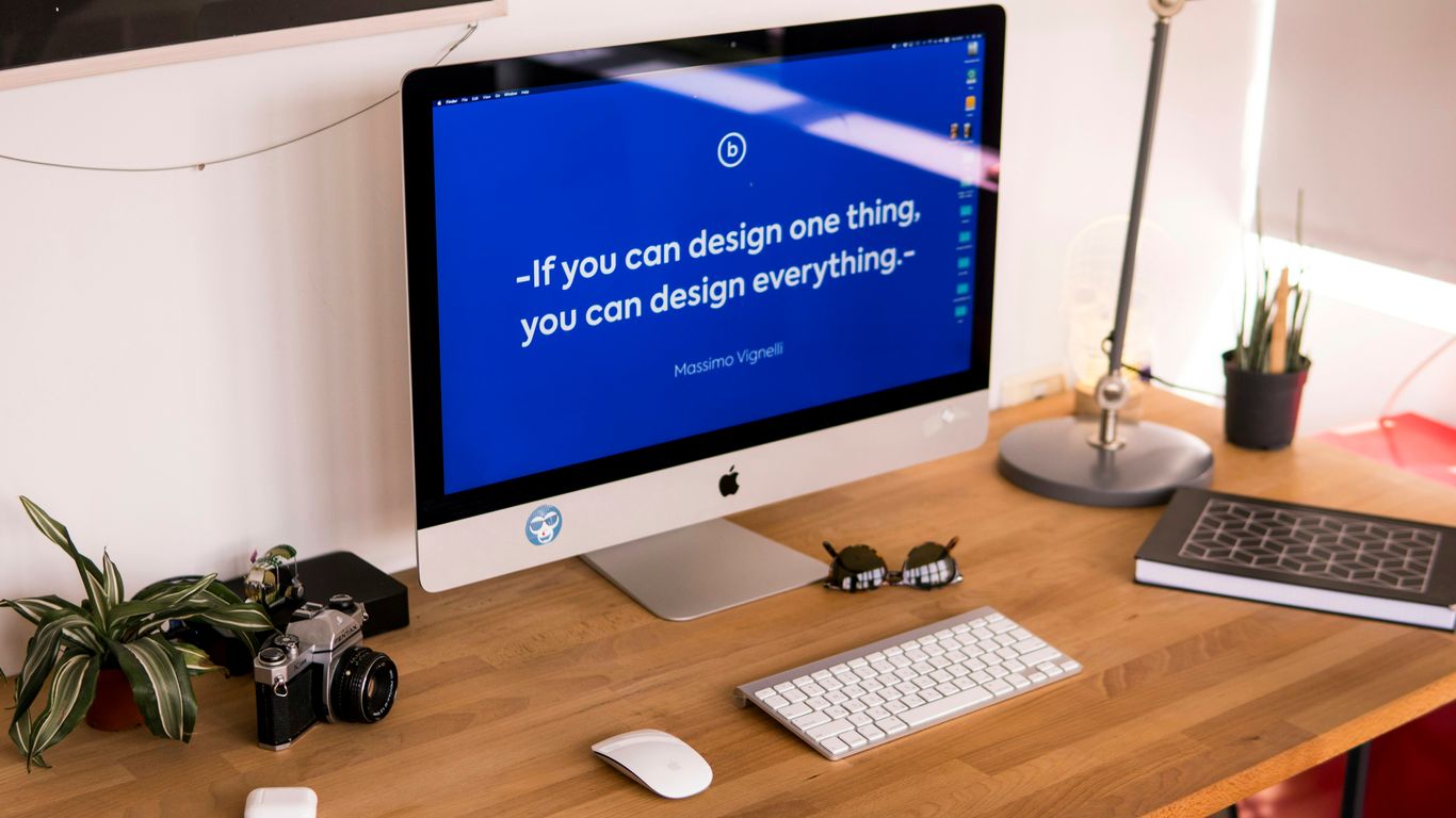 turned on silver iMac on table