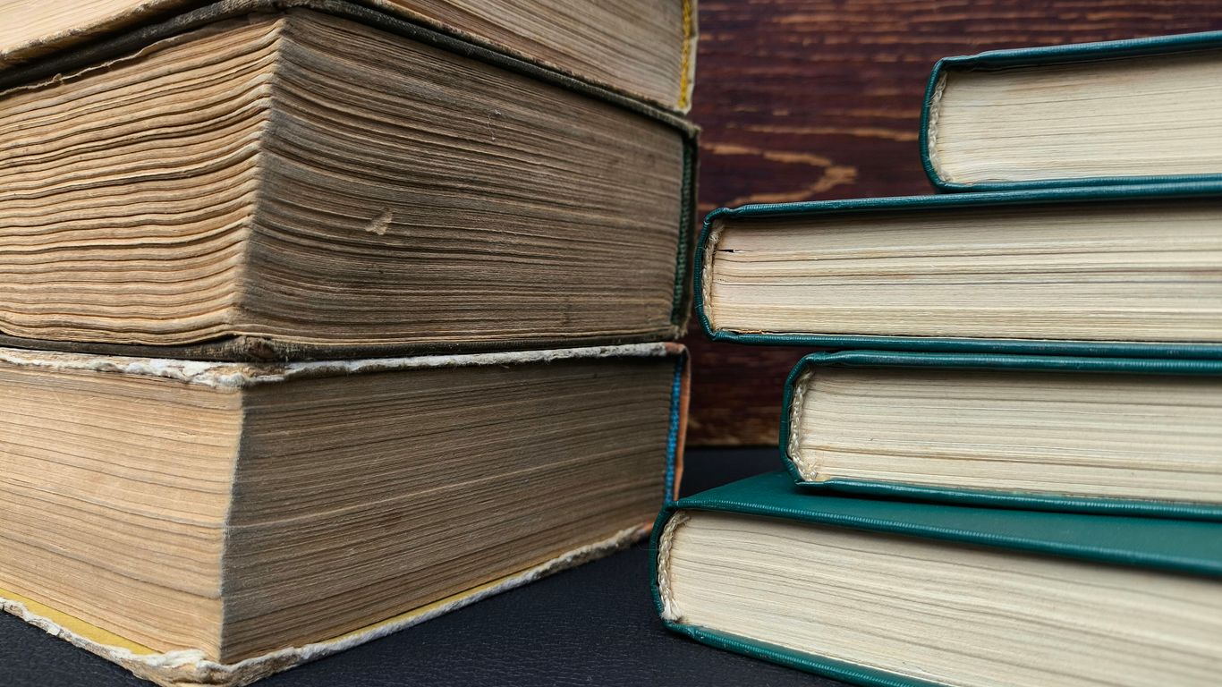 Stack of old books next to modern books
