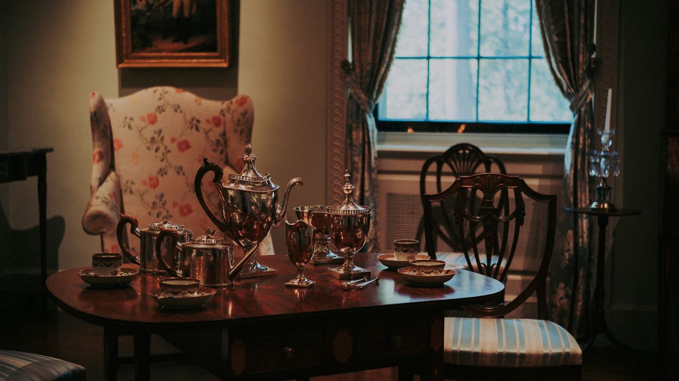 Antique tea set on a table with chairs.
