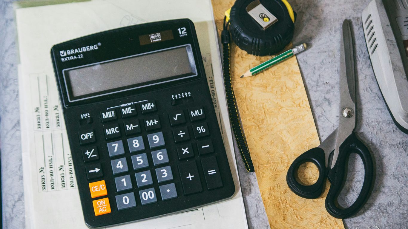 Calculator and office supplies on a desk.