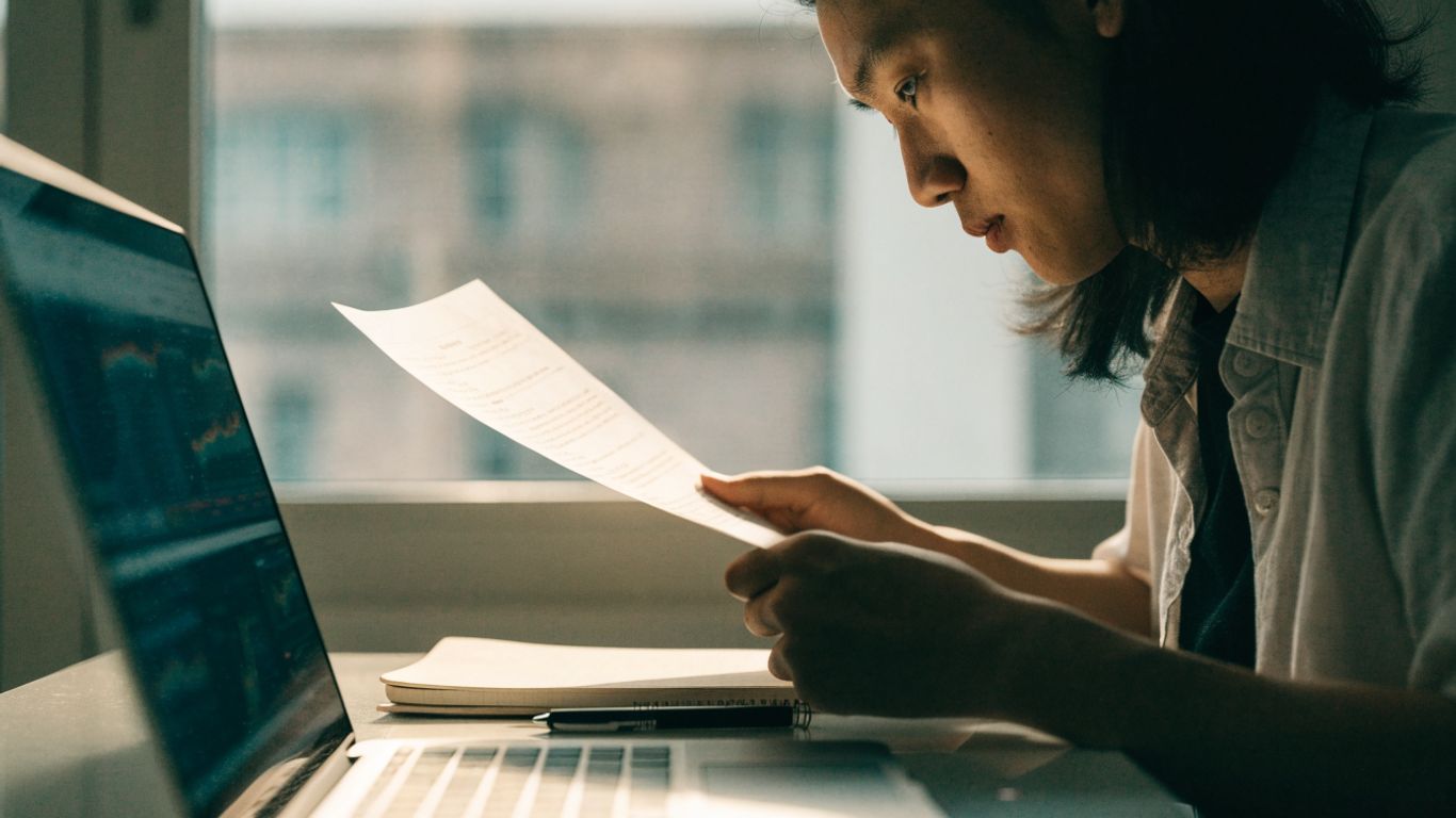 Trader reviewing account terms beside a trading screen