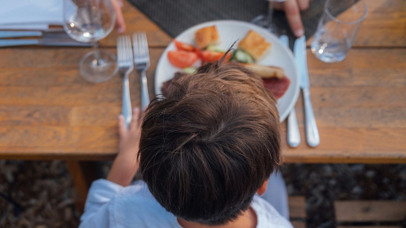 a person sitting at a table with food on it