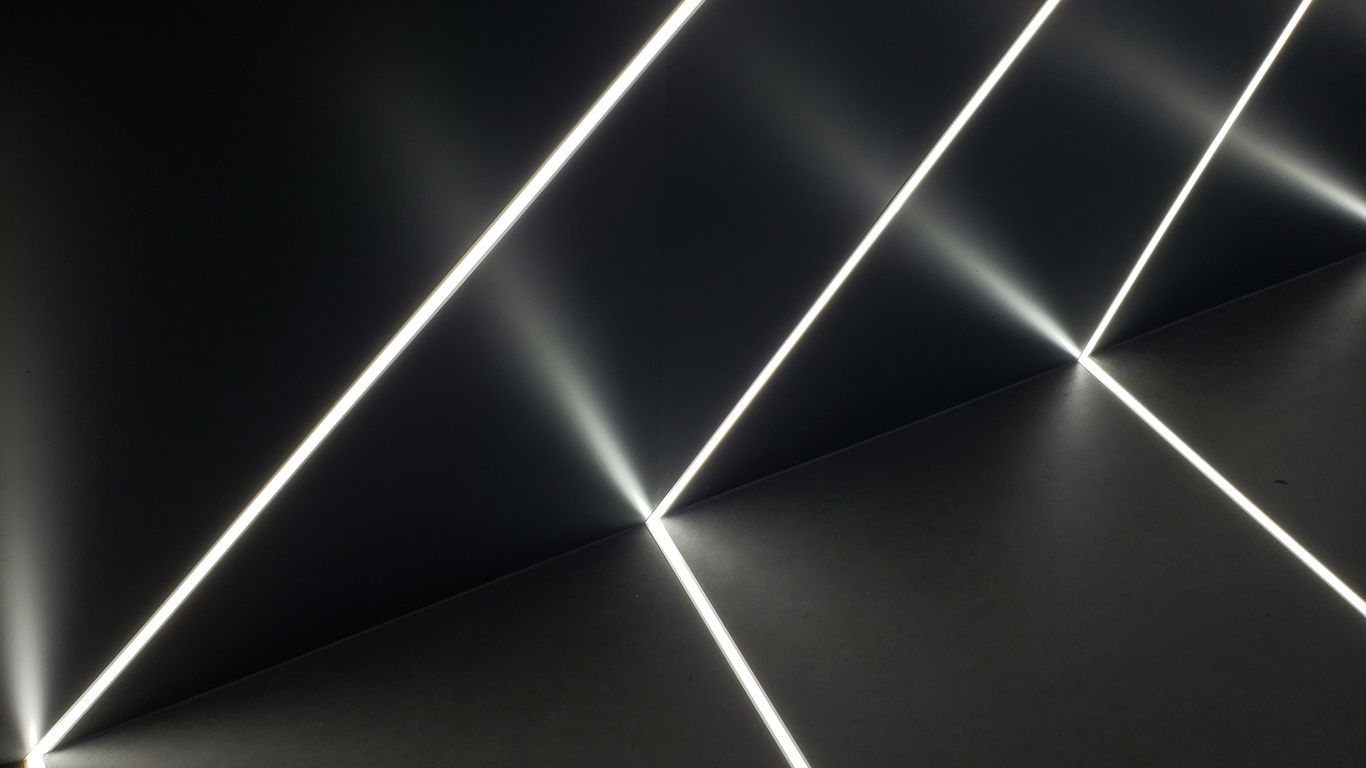 a black wall with white lights shining down on it