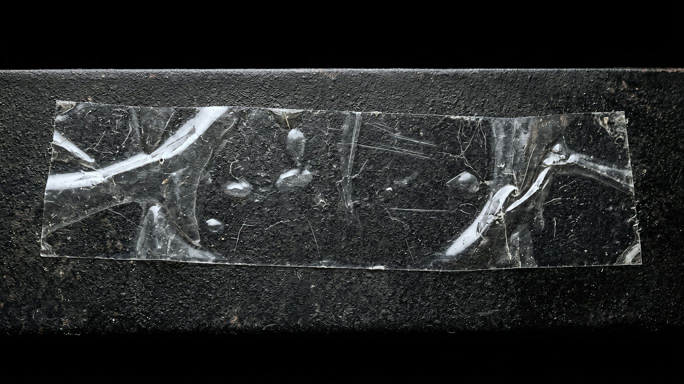 Crinkled clear tape on dark textured surface