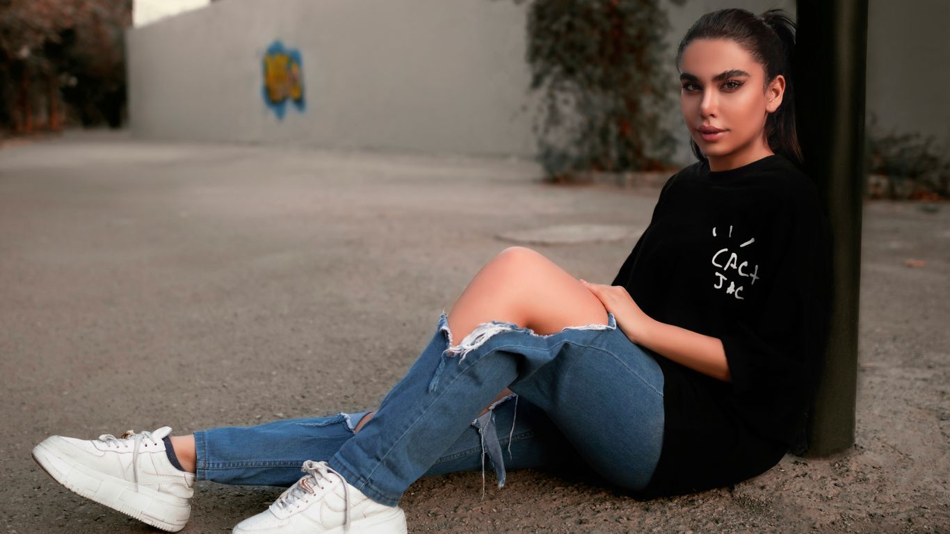 a woman sitting on the ground with her legs crossed