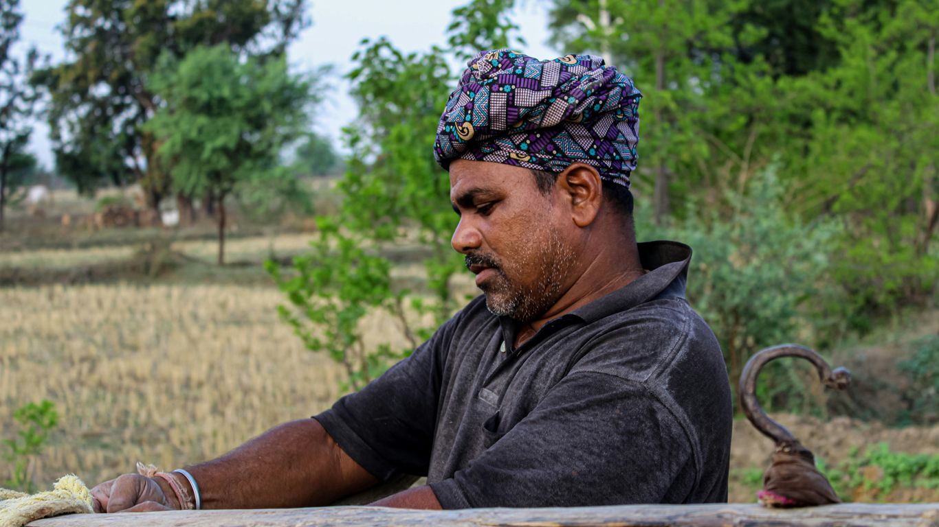 a man with a turban sitting on a log