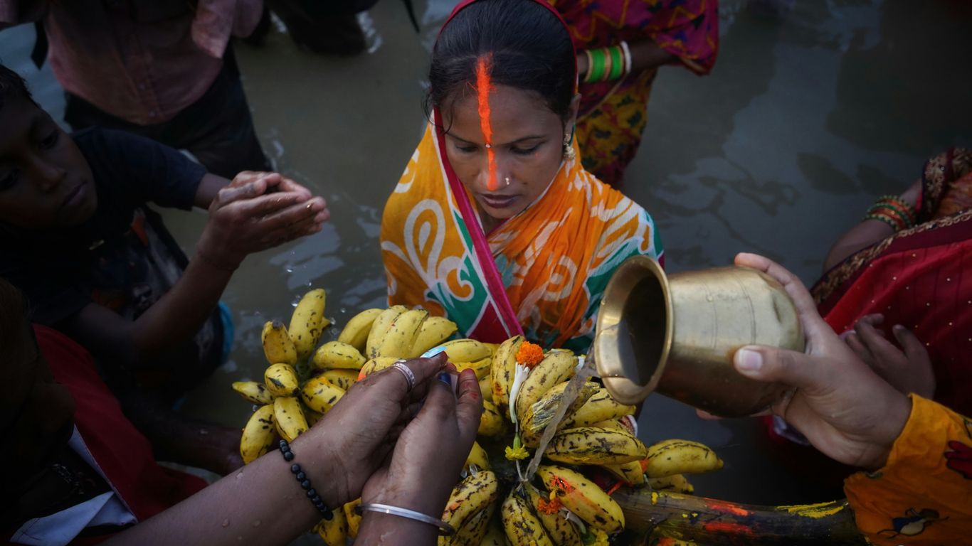 a person pouring a drink into a cup of bananas