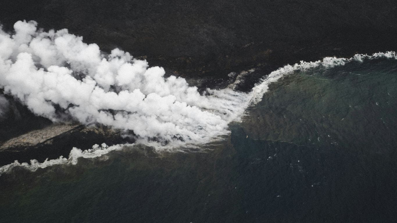 an aerial view of smoke coming out of the ocean