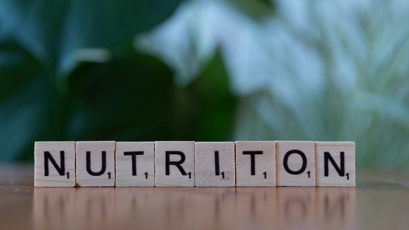 A wooden block spelling nutrition on a table