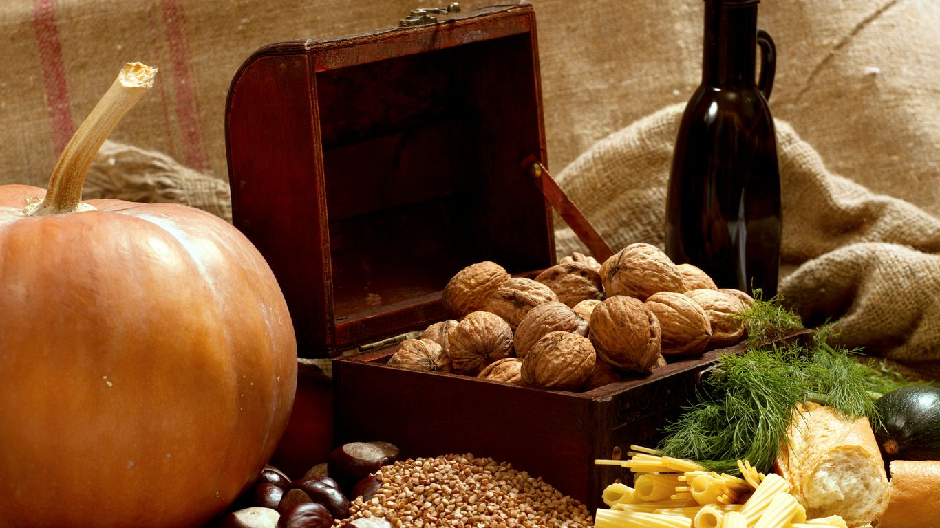a wooden box filled with nuts next to a bottle of wine