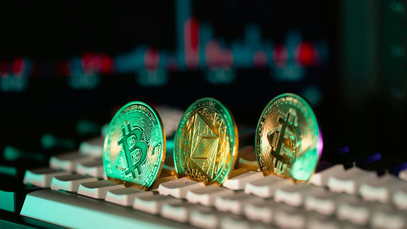 Cryptocurrency coins sit on a keyboard.