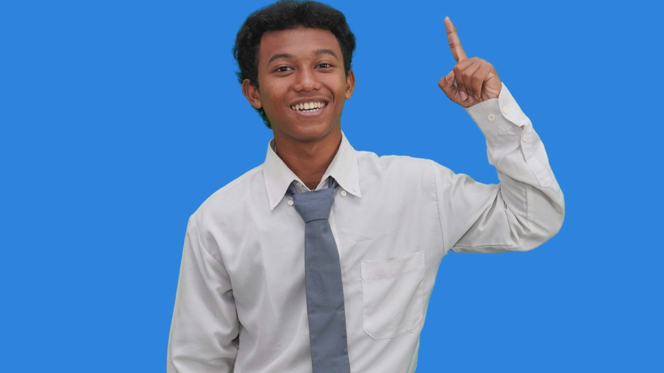 A man in a white shirt and tie pointing at the camera
