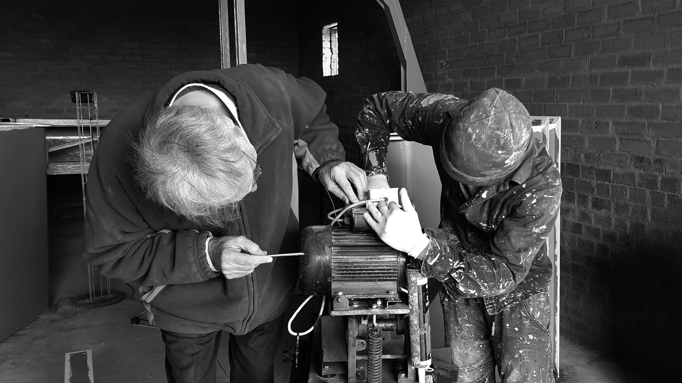 two person fixing AC motor
