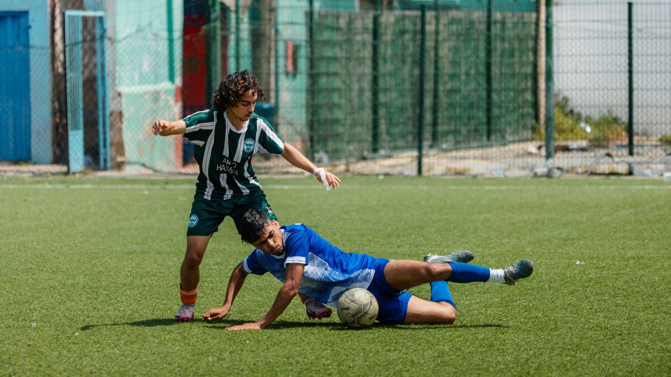 A soccer player makes a tackle on the field.