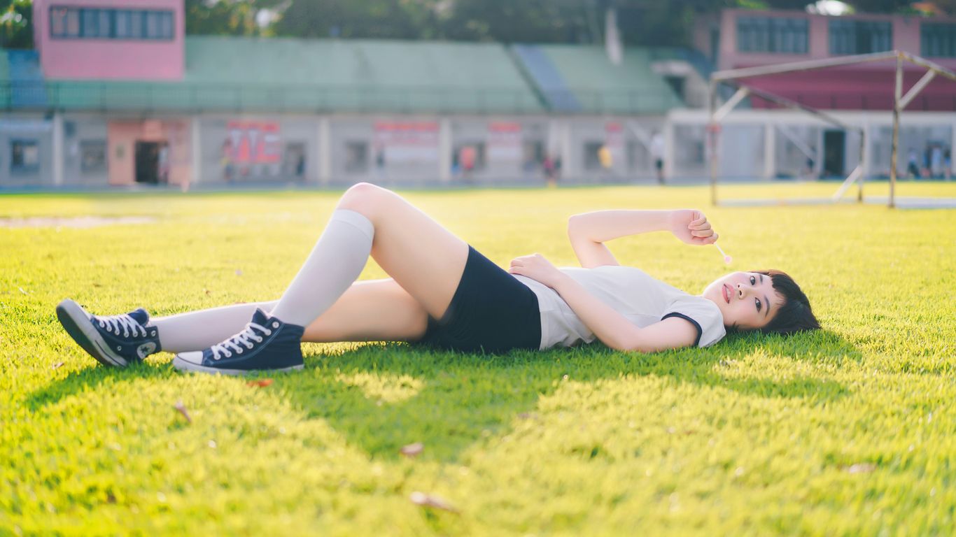 a woman laying on the ground in a field