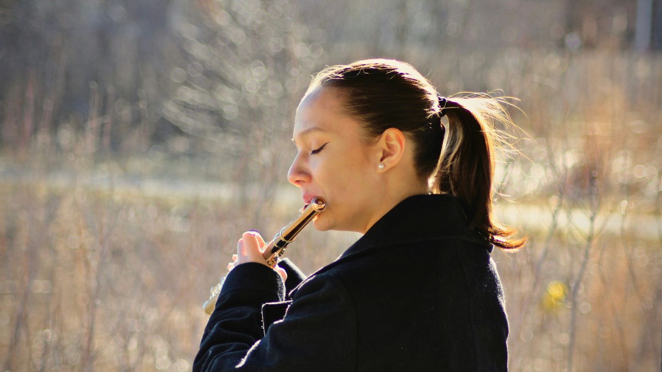 woman playing flute on fields