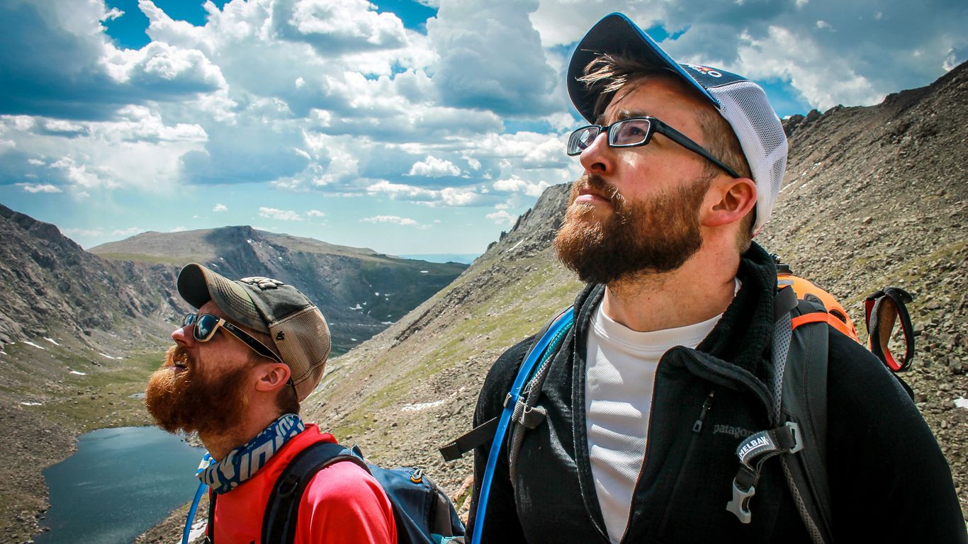 two male hikers looking up at the sky