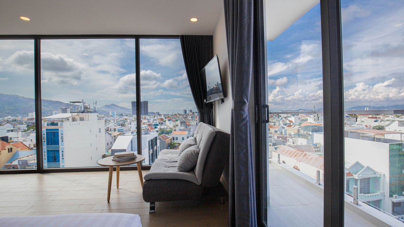 a room with a couch and a window with a view of a city