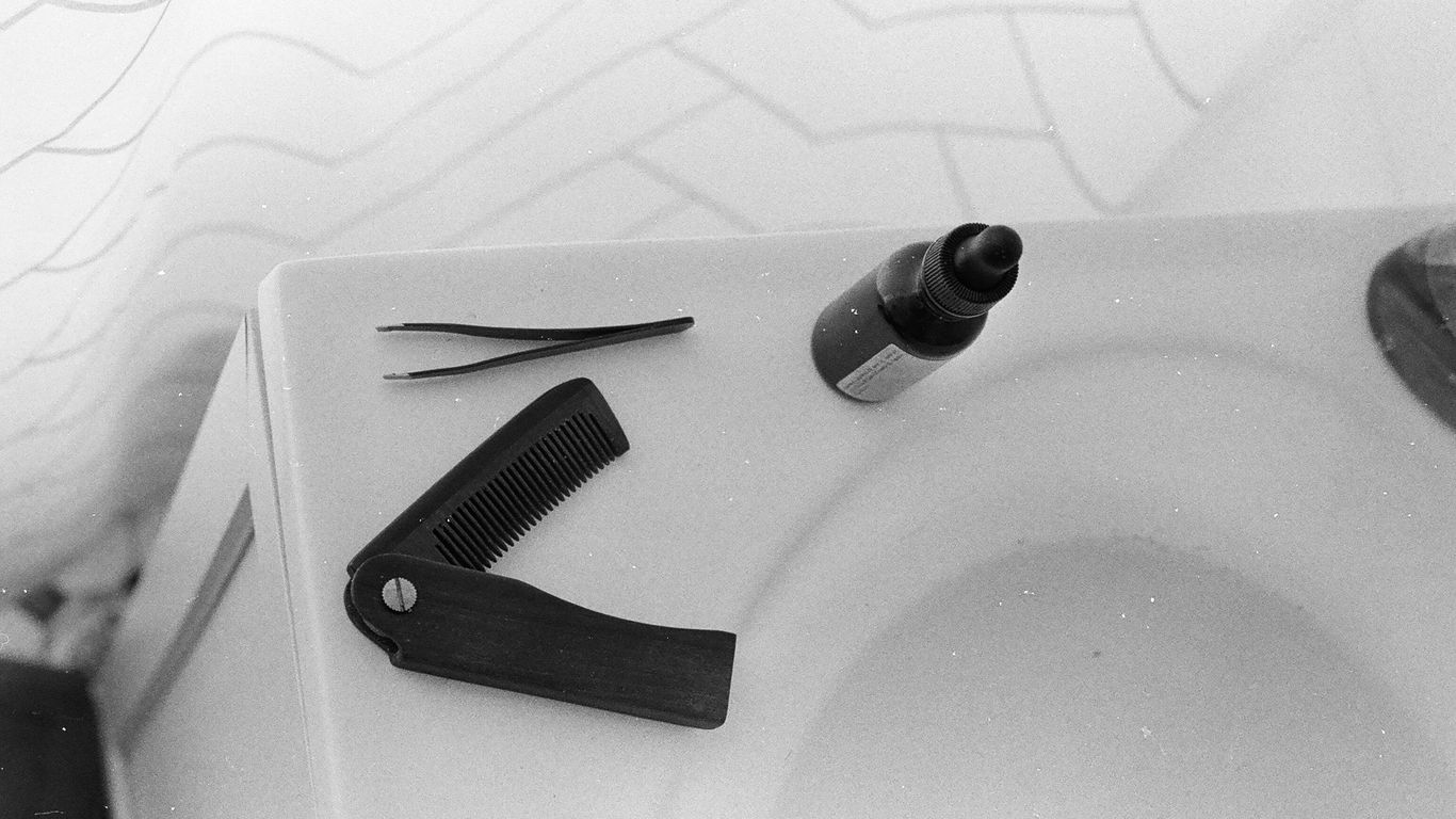 a close up of a sink with a hair dryer and comb