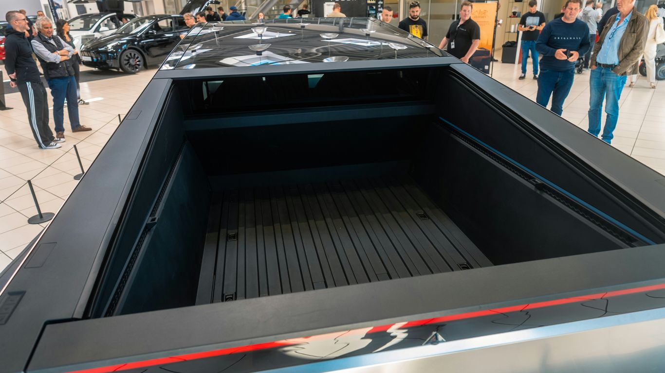A group of people looking at cars in a showroom