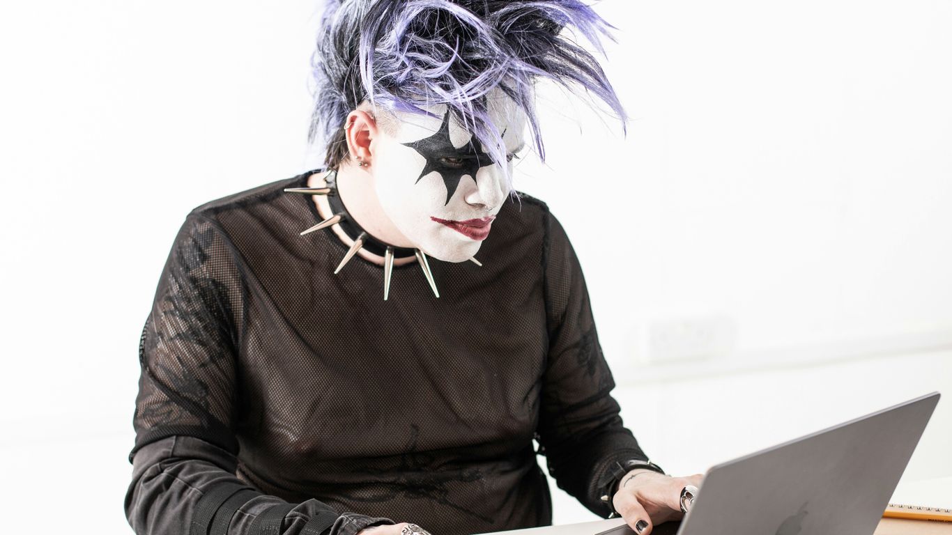 a person in a mask using a laptop