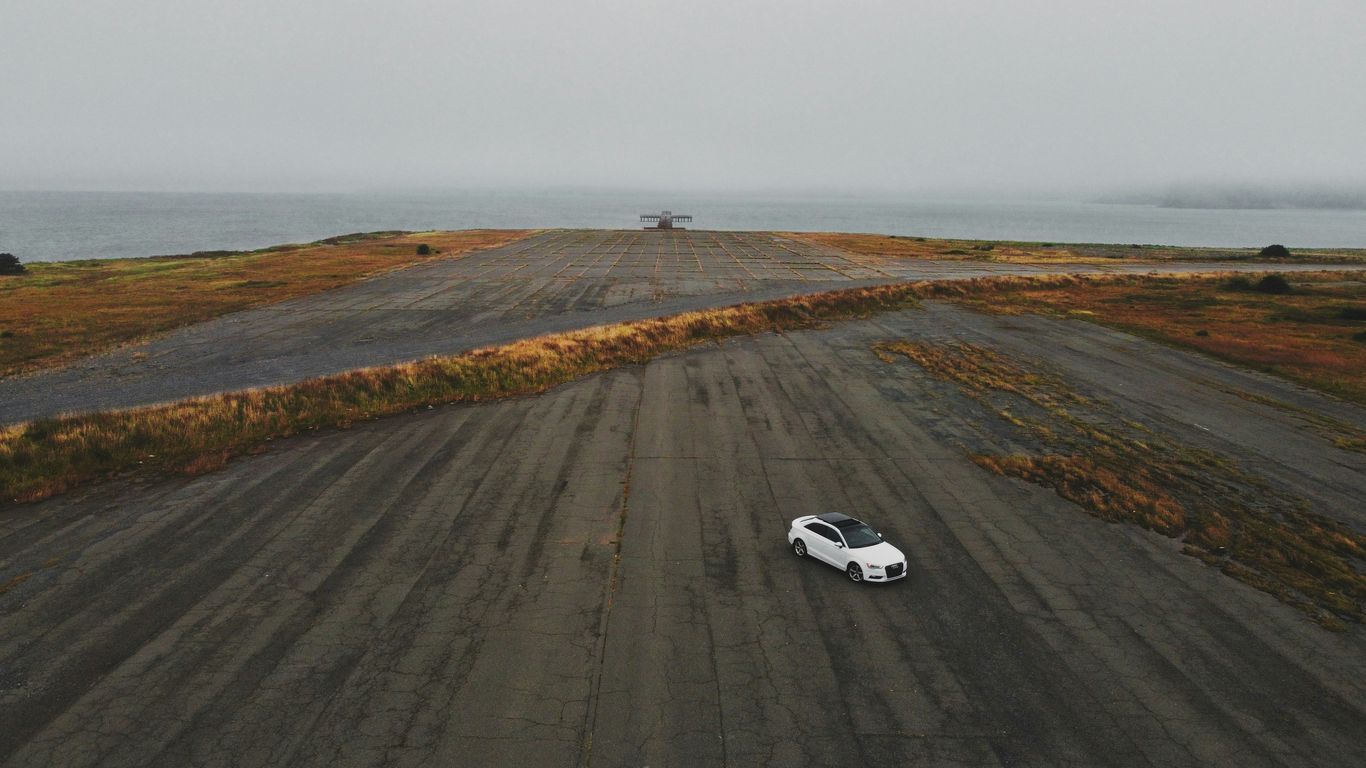 white coupe on gray asphalt road during daytime