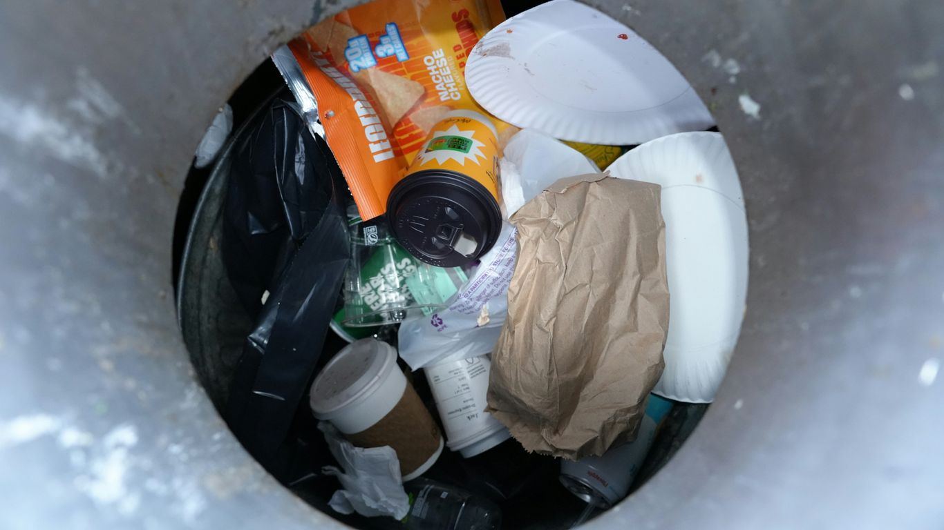 Trash can filled with various discarded items.