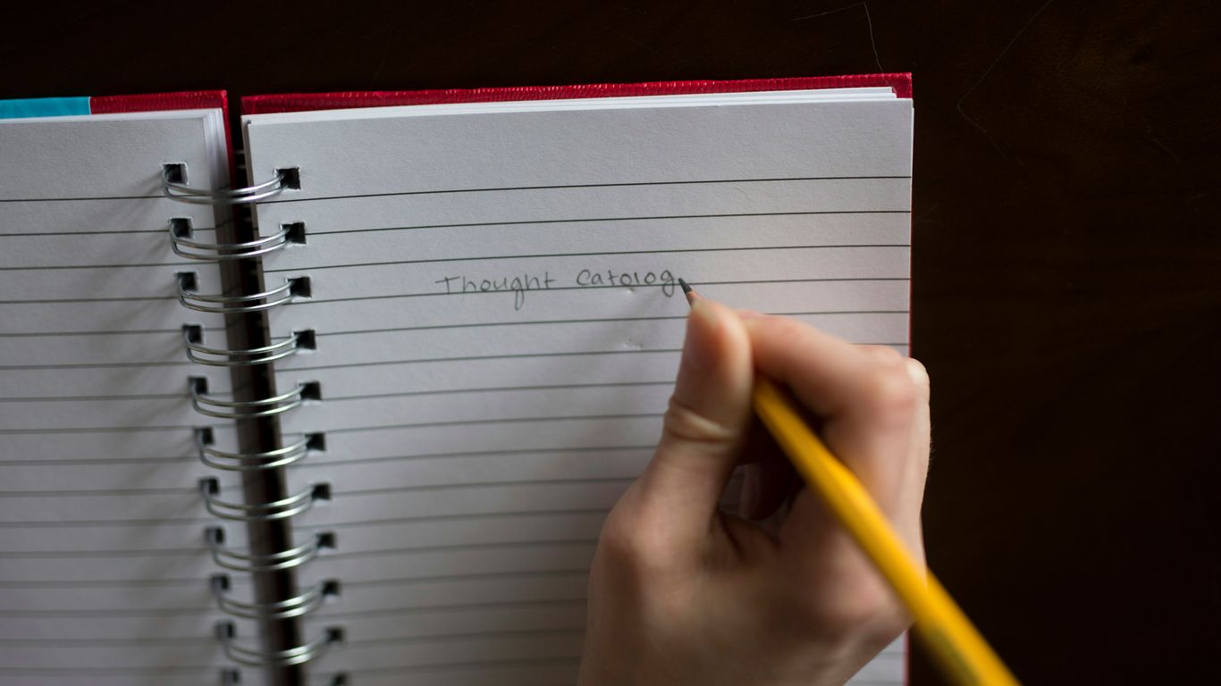 person writing on notebook
