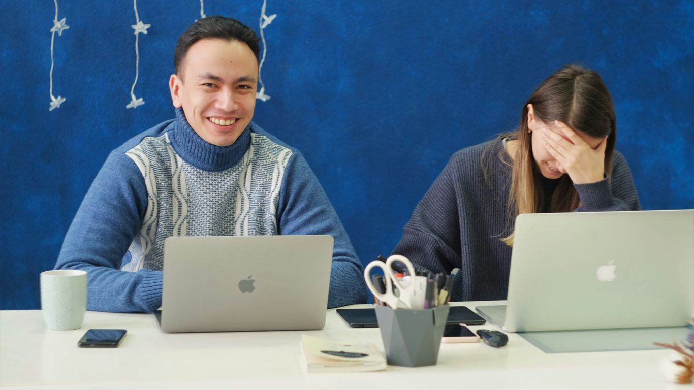 woman in gray sweater using silver macbook