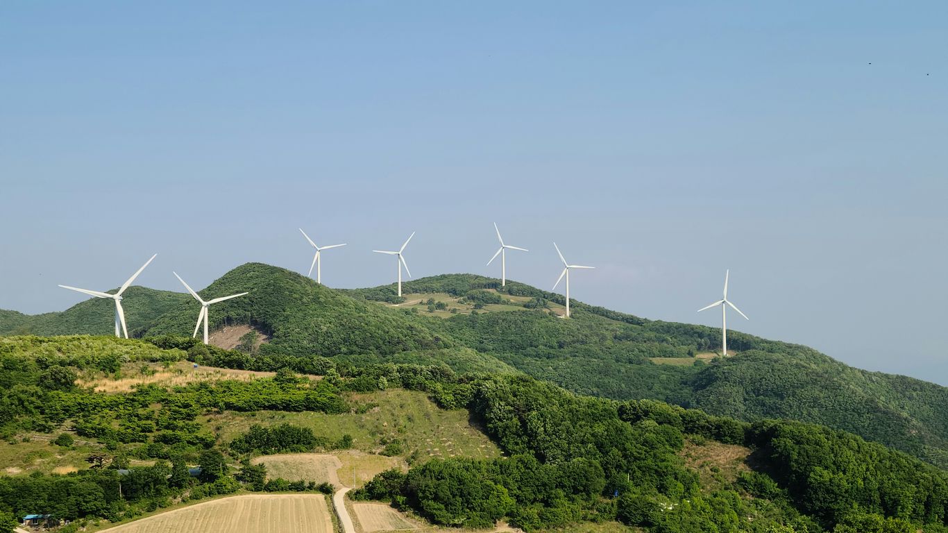 a group of wind turbines on a hill
