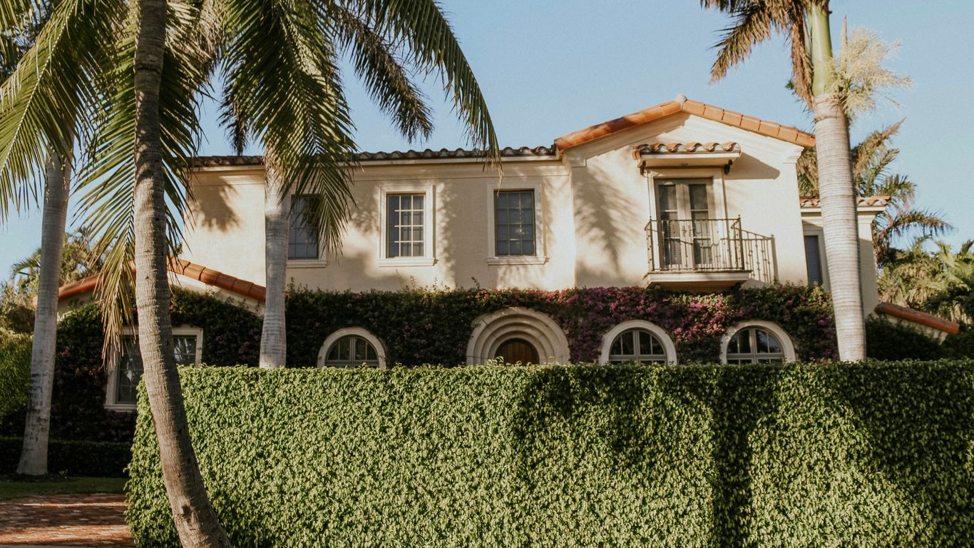 green trees near white concrete house during daytime