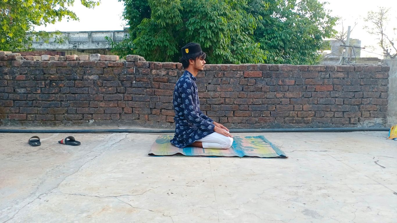 woman in blue and white floral dress sitting on blue mat