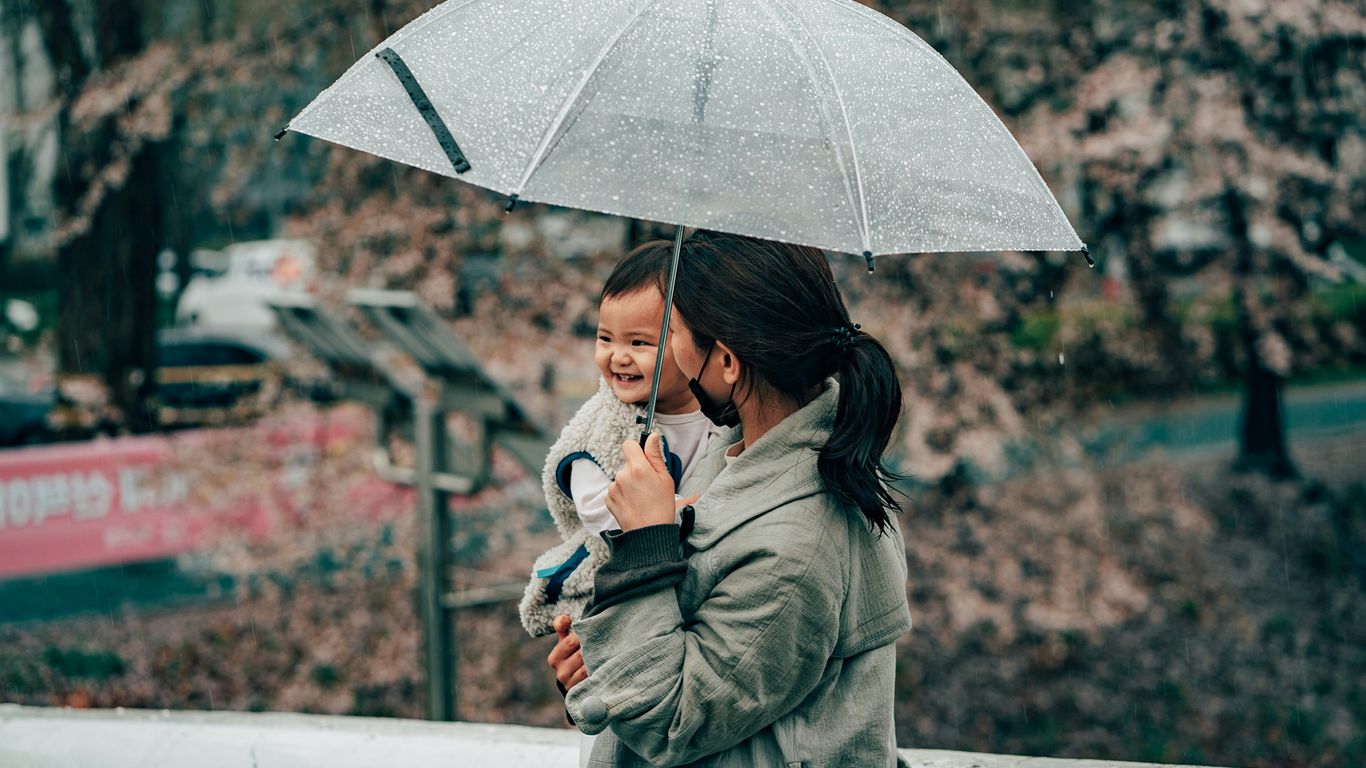woman in green coat holding umbrella