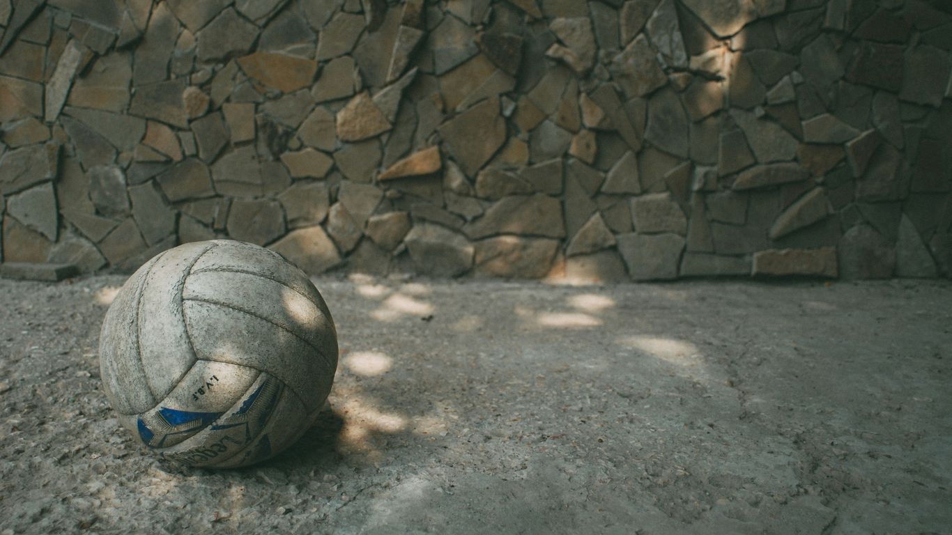 white and blue soccer ball on gray concrete floor