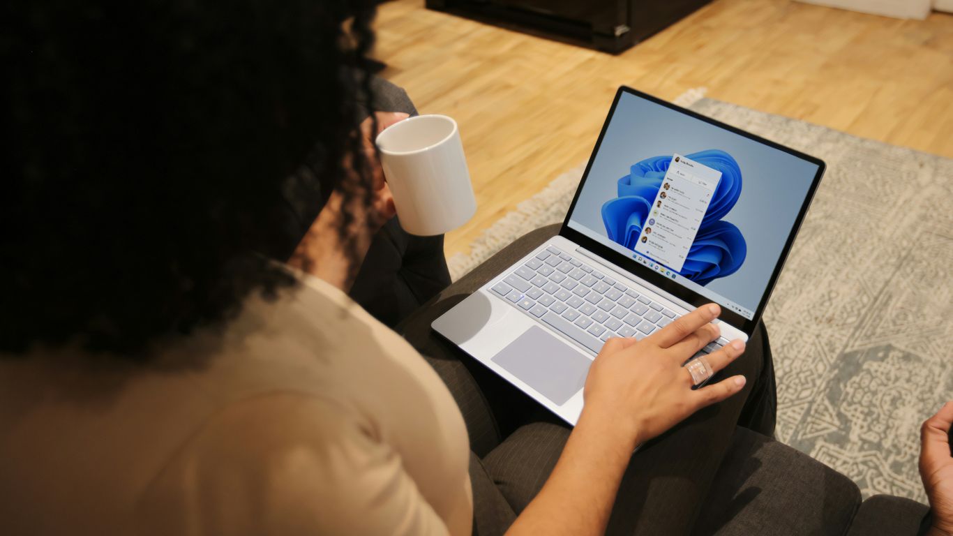 Female on her Microsoft laptop at work drinking coffee