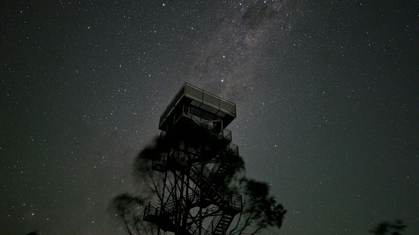 a tower that is under a night sky filled with stars
