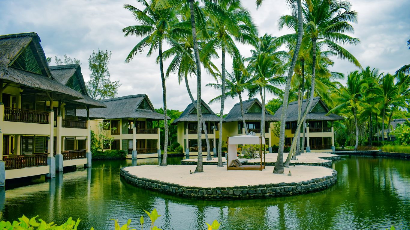 brown and white wooden house near body of water during daytime