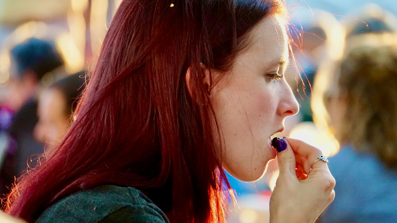 woman in green shirt holding her mouth