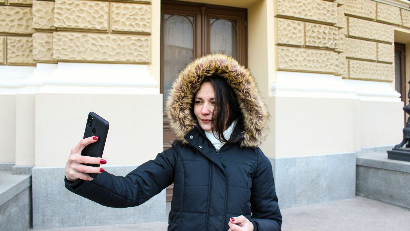 a woman in a parka holding a cell phone