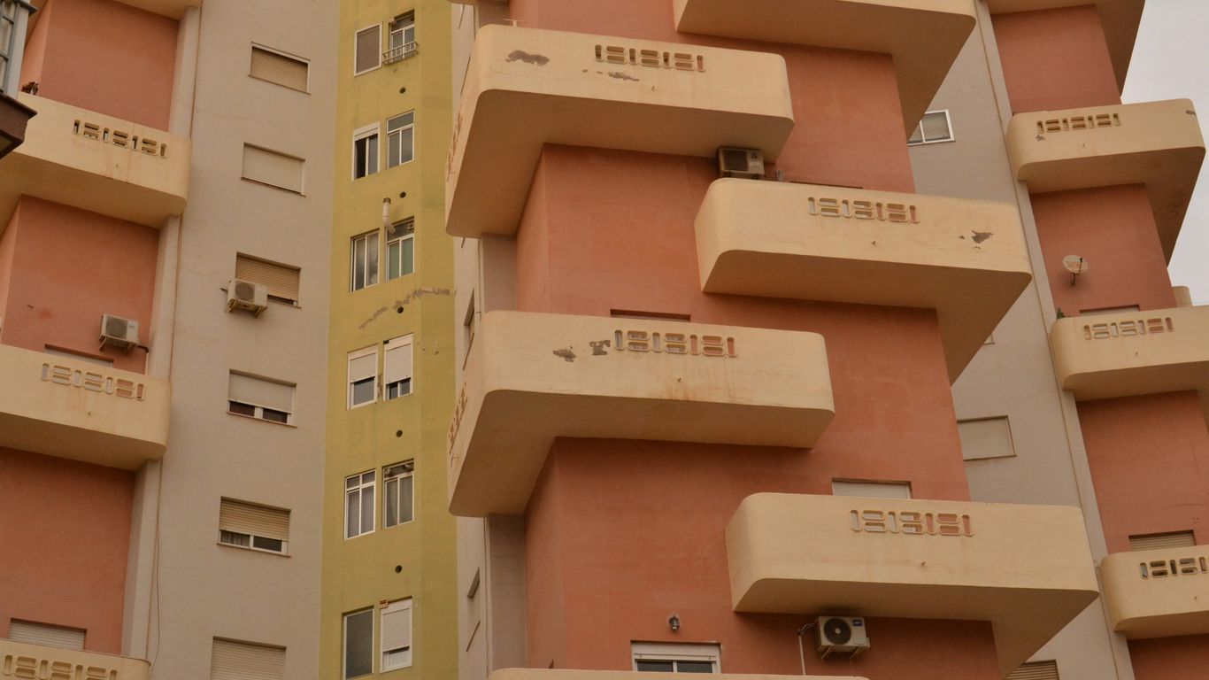 A tall building with lots of windows and balconies