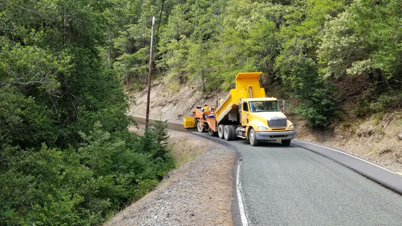 a man standing on the side of a road next to a truck