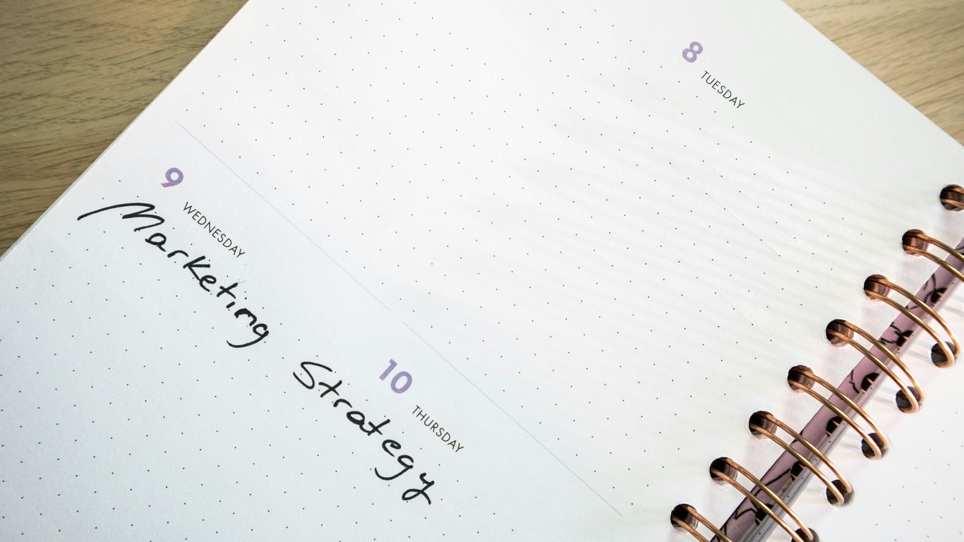 a planner with a pen on top of it