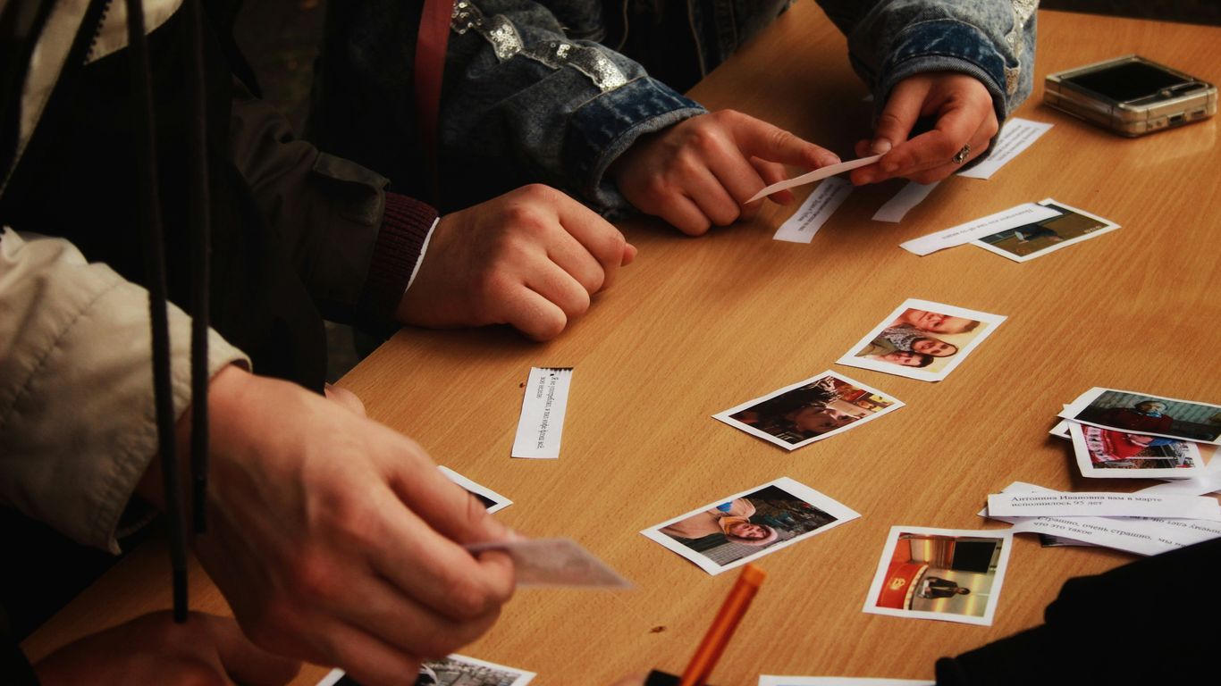 People playing a card game at a wooden table
