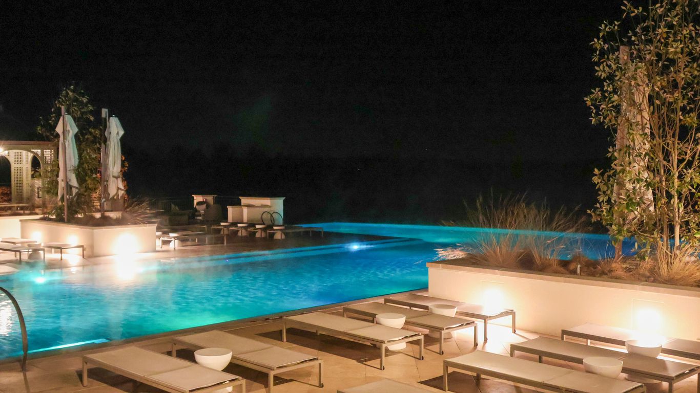 A large swimming pool with lounge chairs around it