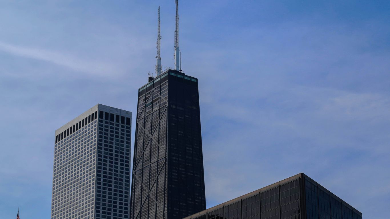 two skyscrapers against a blue sky with a few clouds