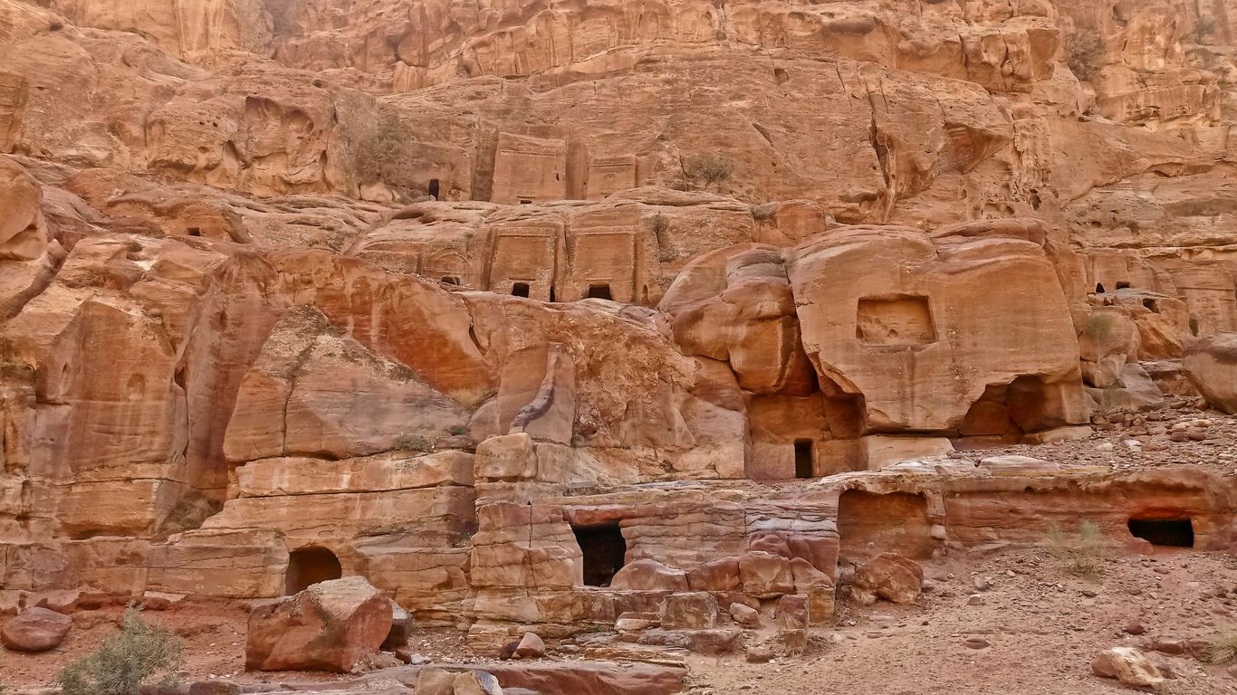 a group of people standing in front of a rock formation