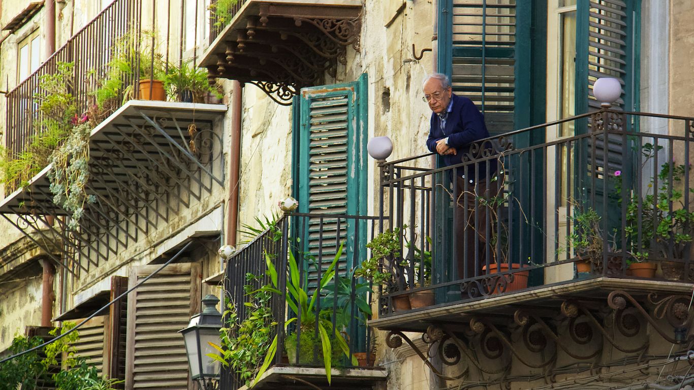 man in blue jacket standing on the balcony
