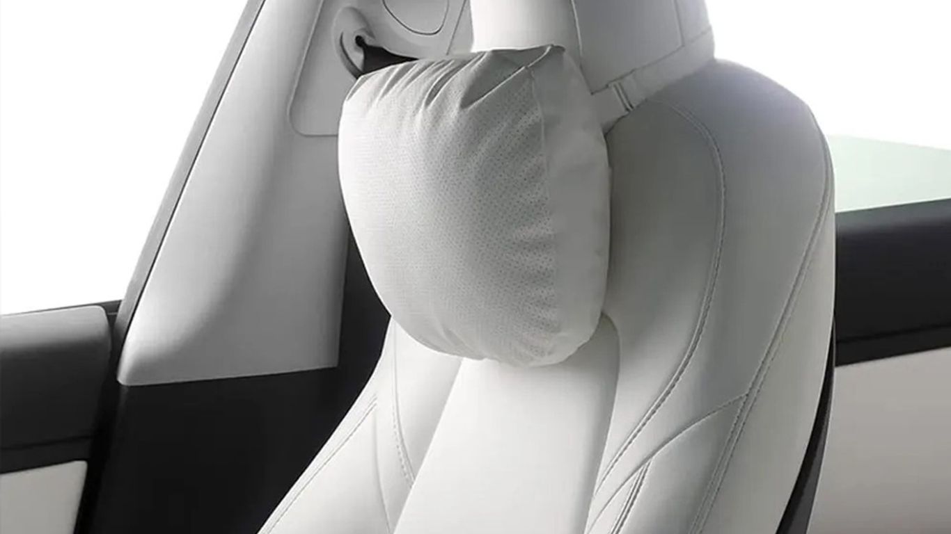 A sleek car seat with a comfortable neck pillow attached.